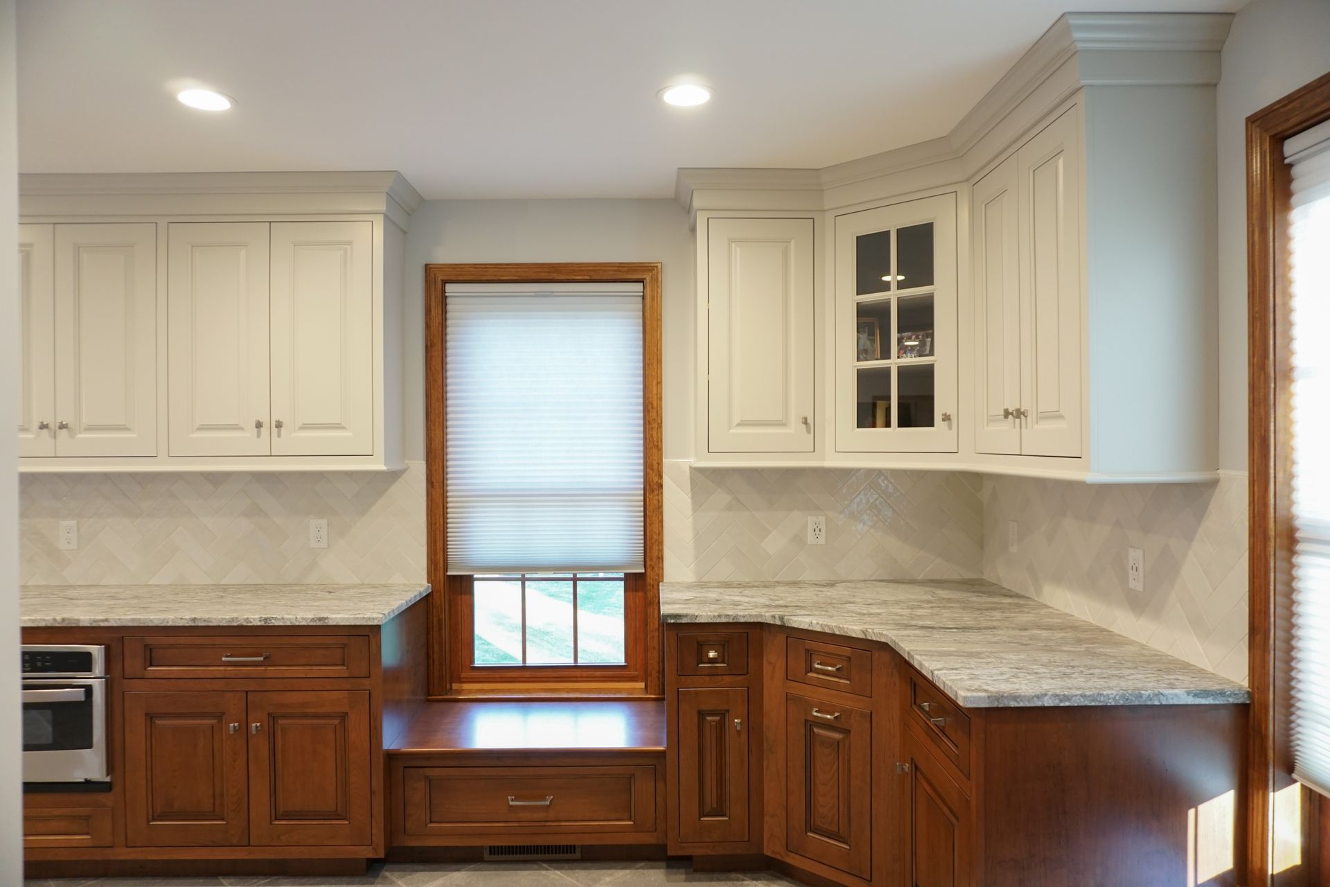 a kitchen with white cabinets and a window