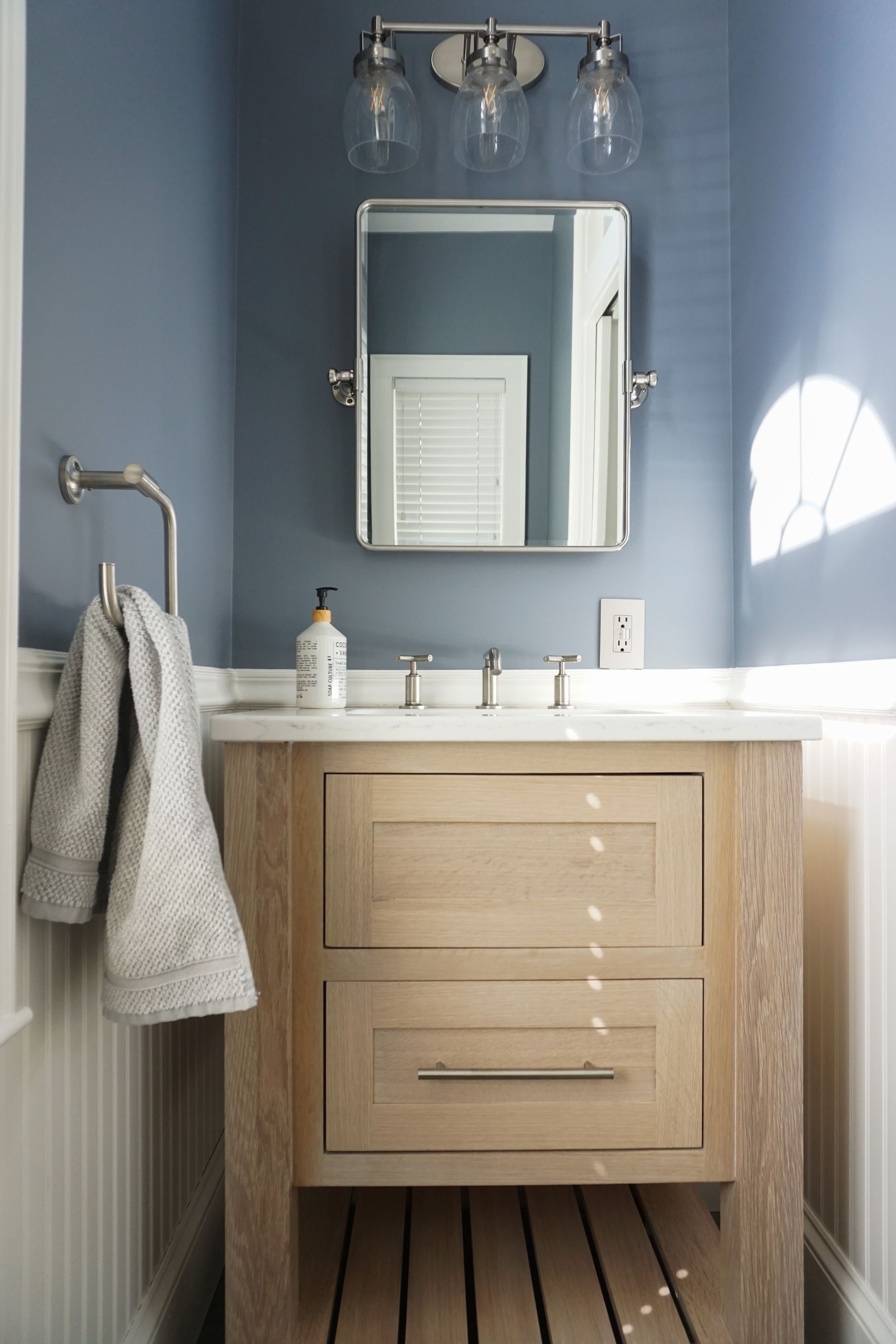 A bathroom with a wooden vanity and a mirror.