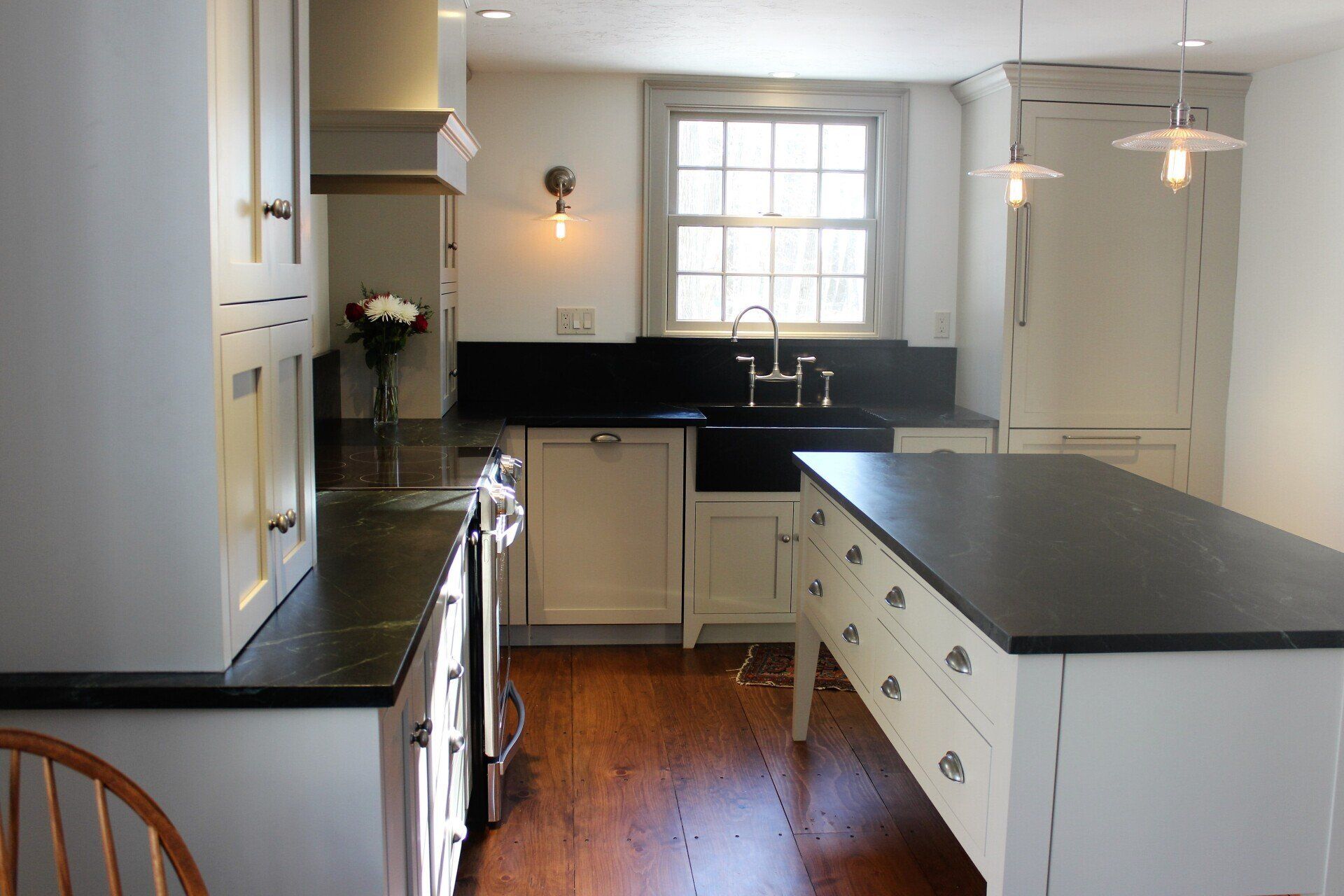 a kitchen with white cabinets and black counter tops