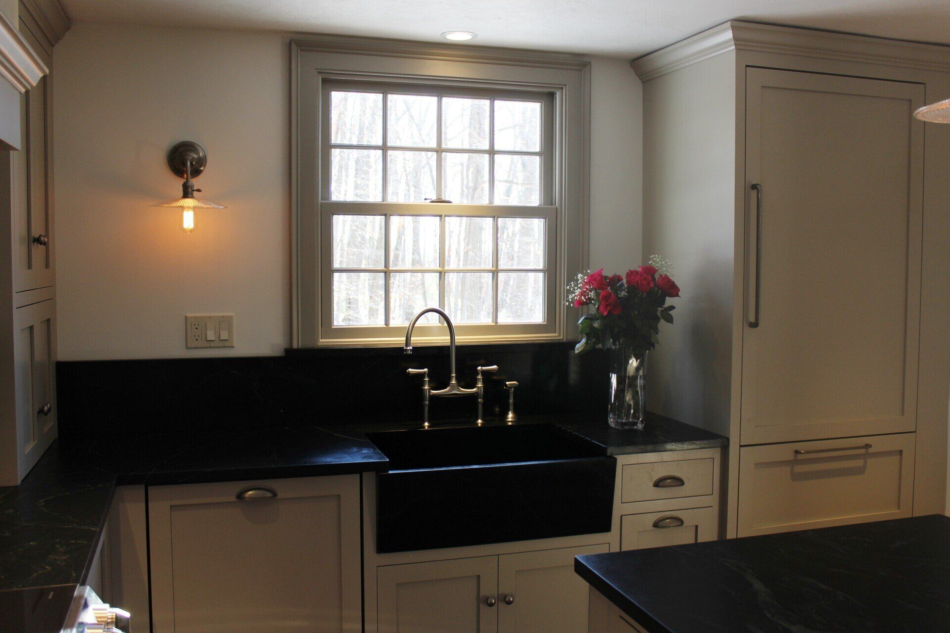 a kitchen with a black sink and white cabinets