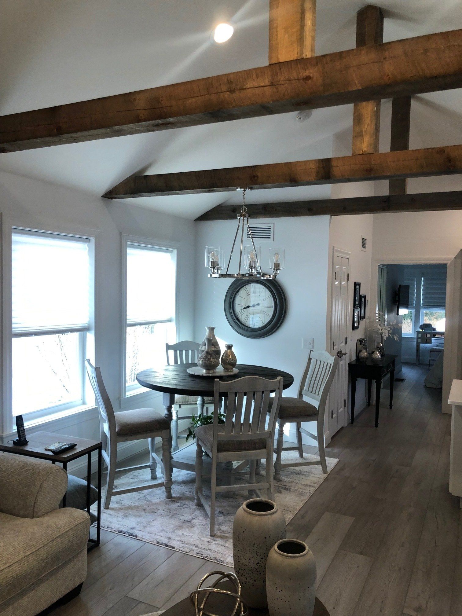 A living room with a table and chairs and a mirror on the wall