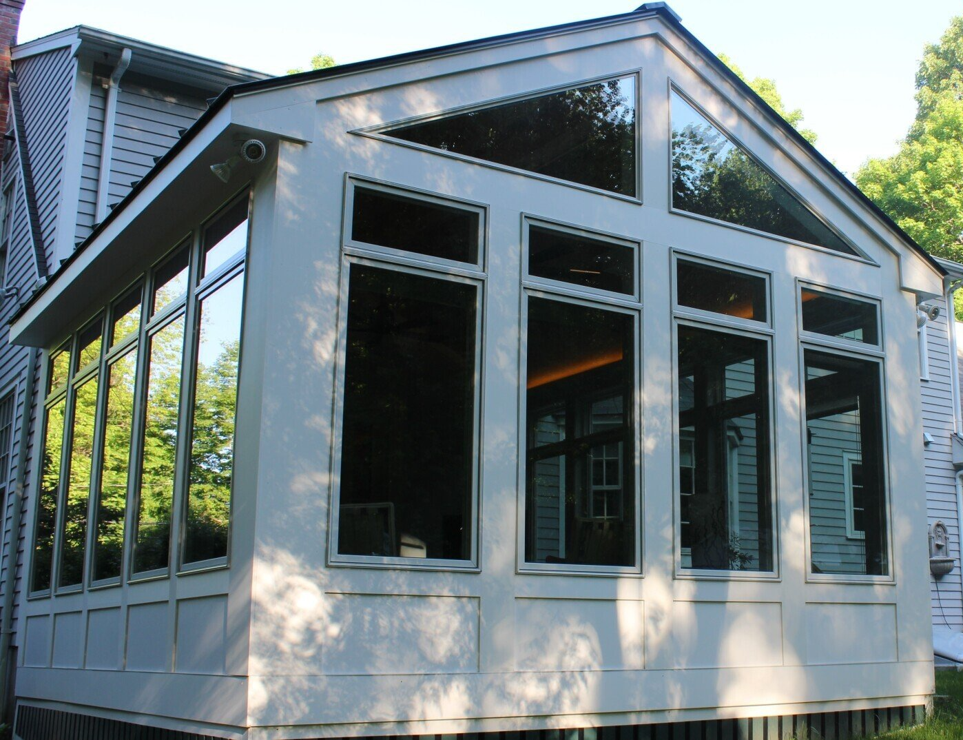 A white house with a lot of windows and trees in the background