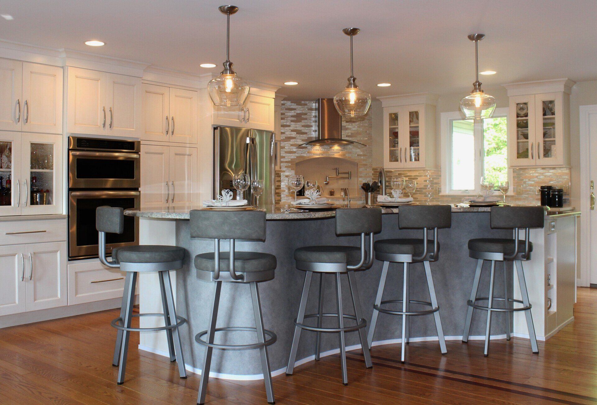 a kitchen with white cabinets and a stainless steel refrigerator