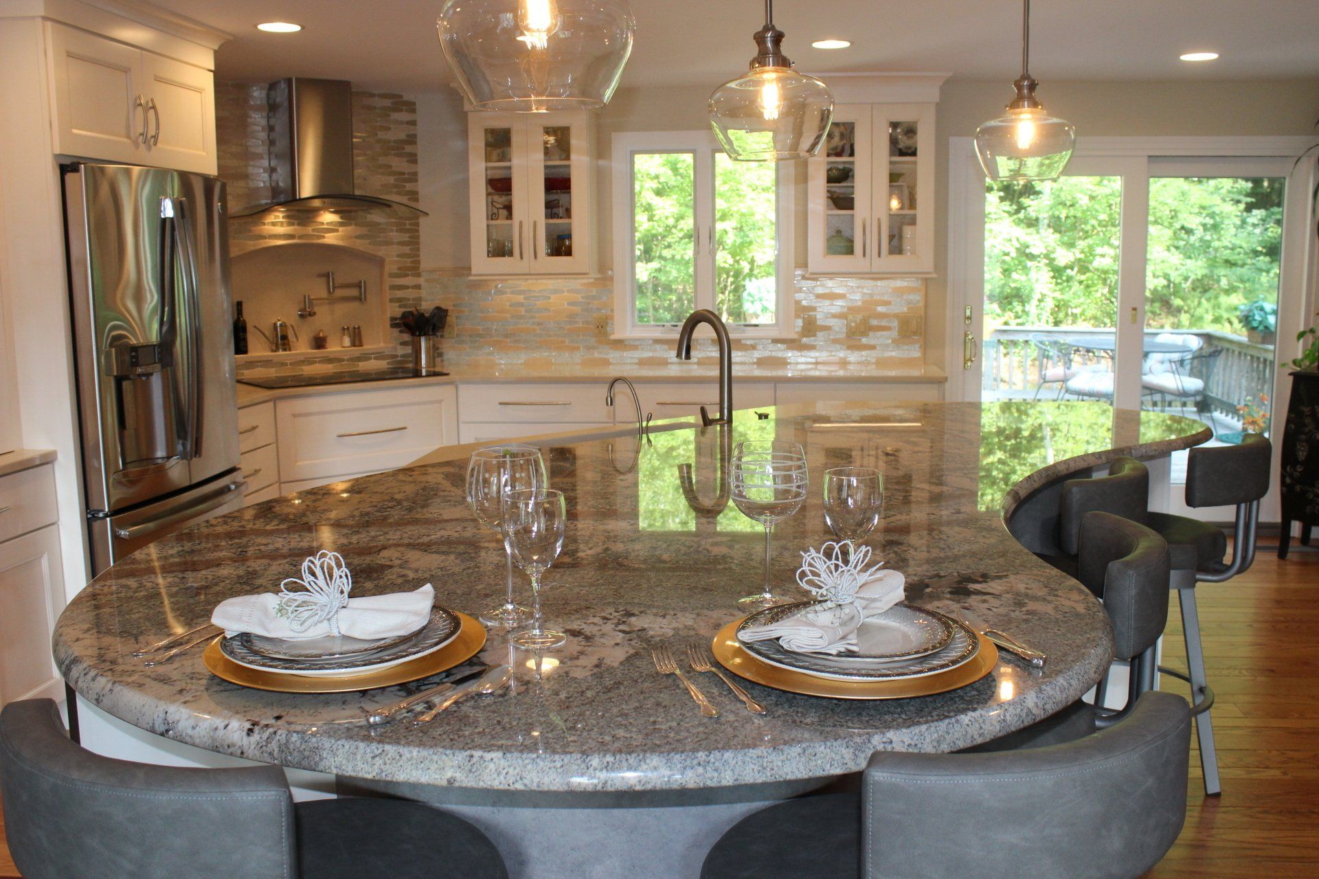 a kitchen with a large island with plates and glasses on it