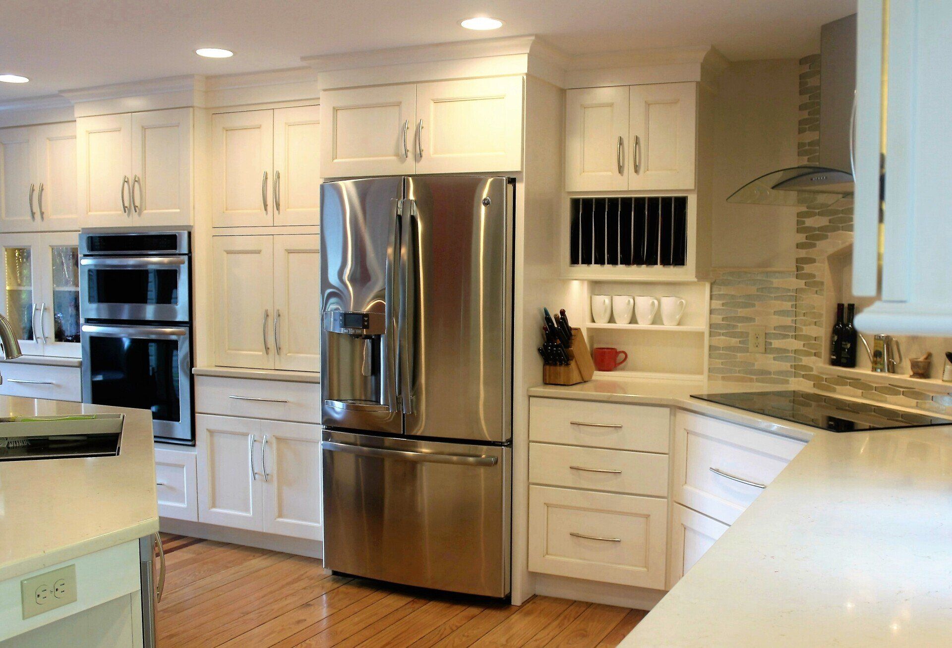 a kitchen with white cabinets and a stainless steel refrigerator