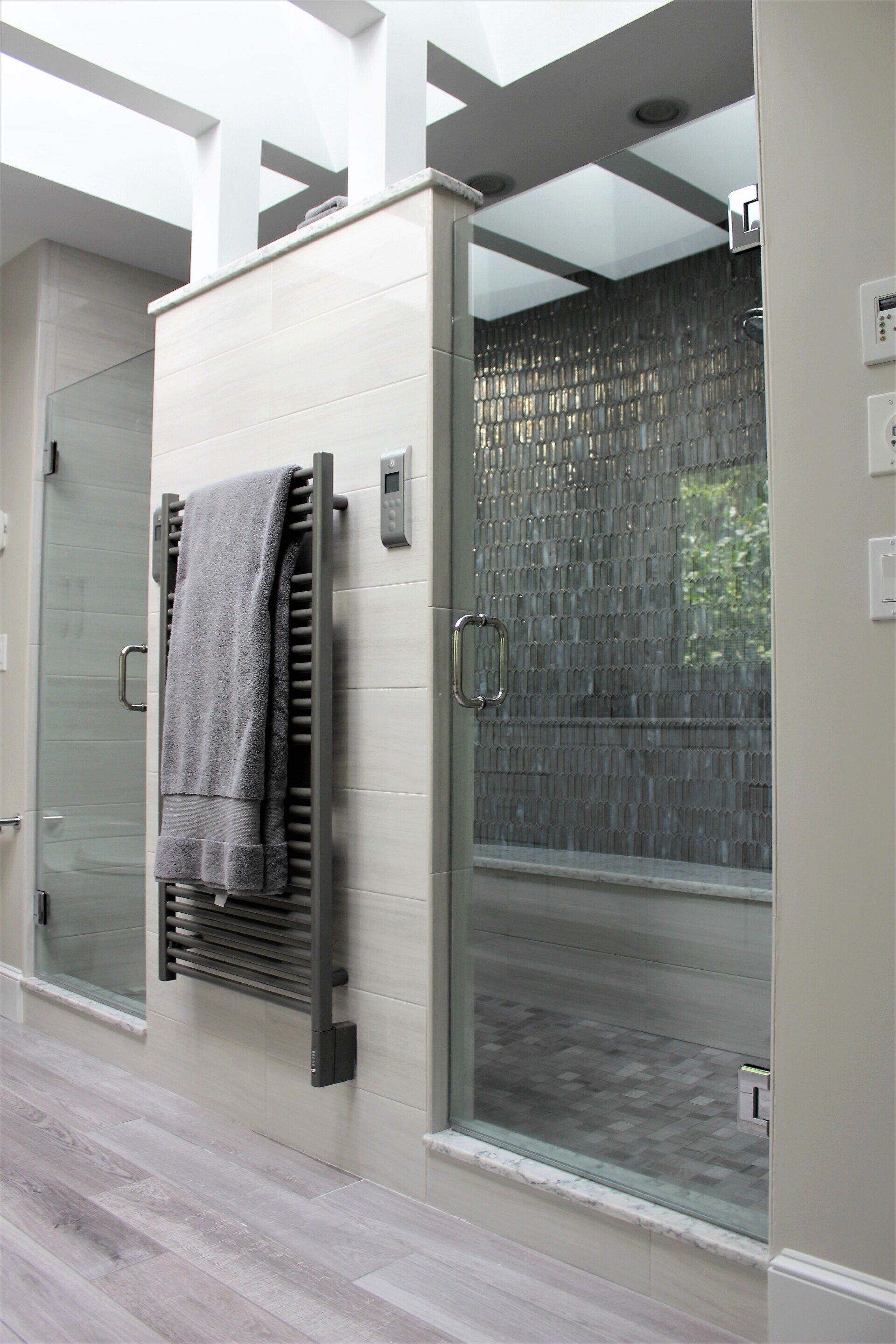 New bathroom renovation in Western MA featuring light gray tile and designer green shower tile with towel heating rack