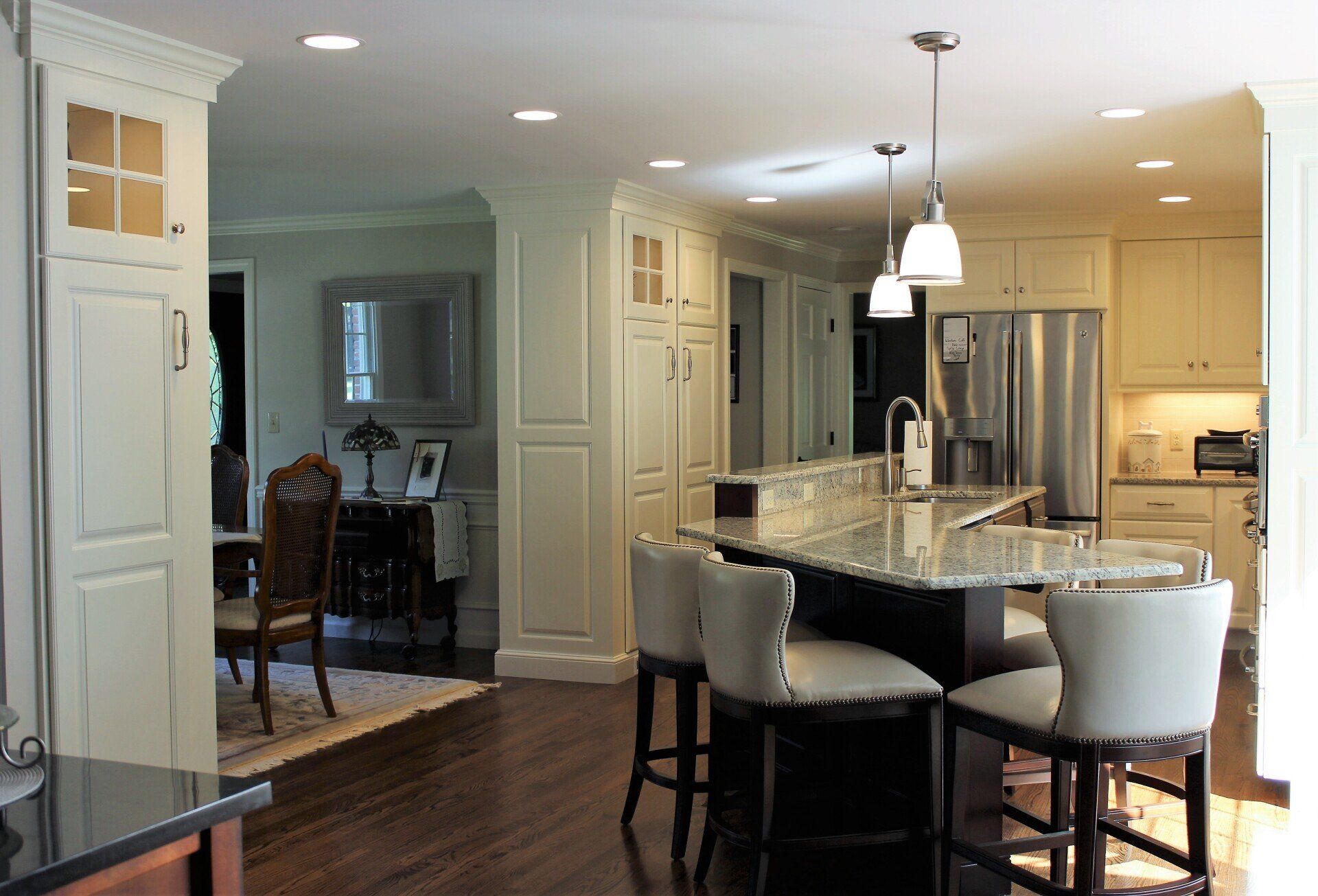 a kitchen with white cabinets and a stainless steel refrigerator