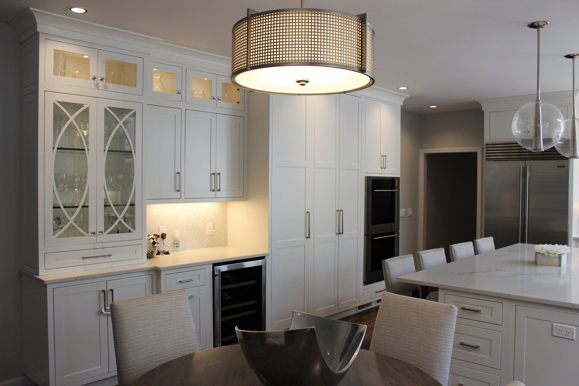 a kitchen with white cabinets and a stainless steel refrigerator