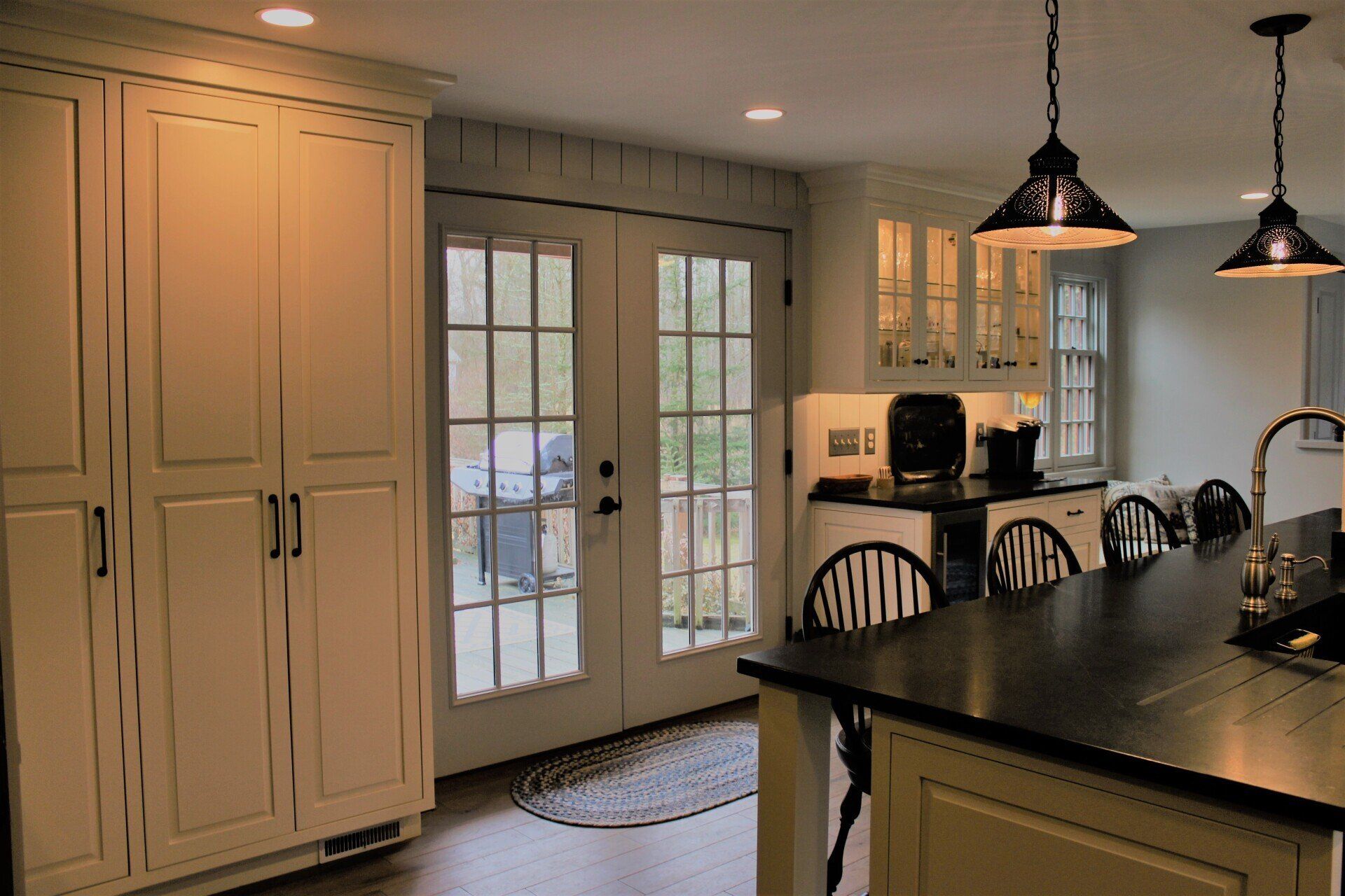 a kitchen with white cabinets and black counter tops