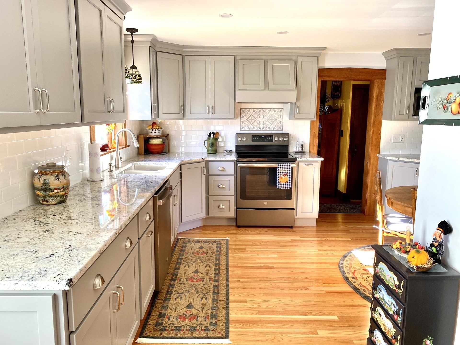 a kitchen with gray cabinets and stainless steel appliances