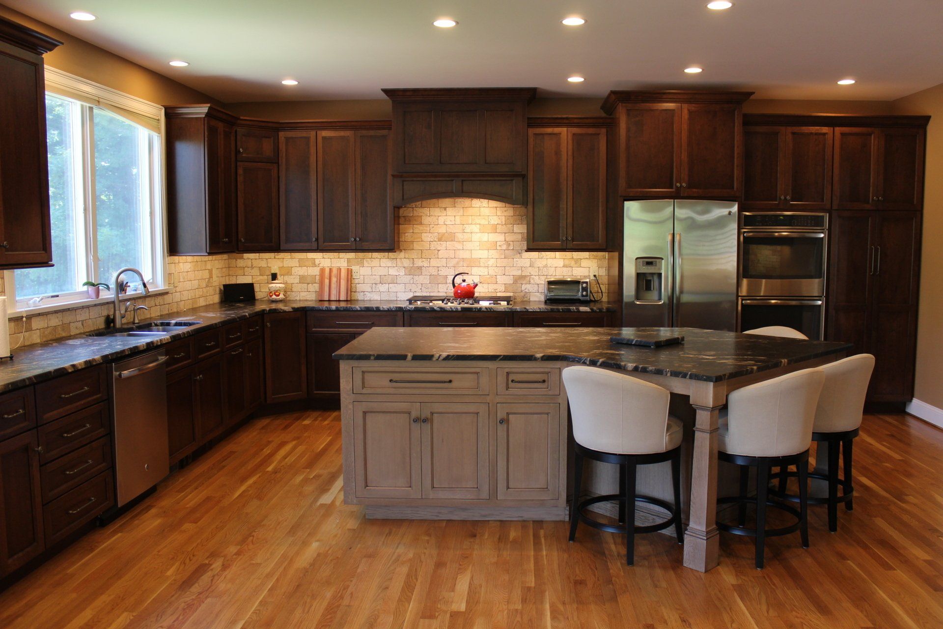 a kitchen with dark cabinets and stainless steel appliances