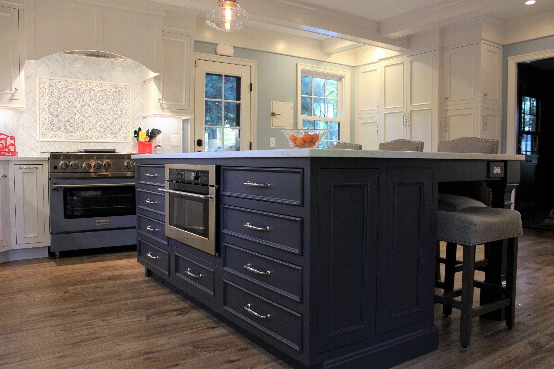 a kitchen with blue cabinets and a wolf stove
