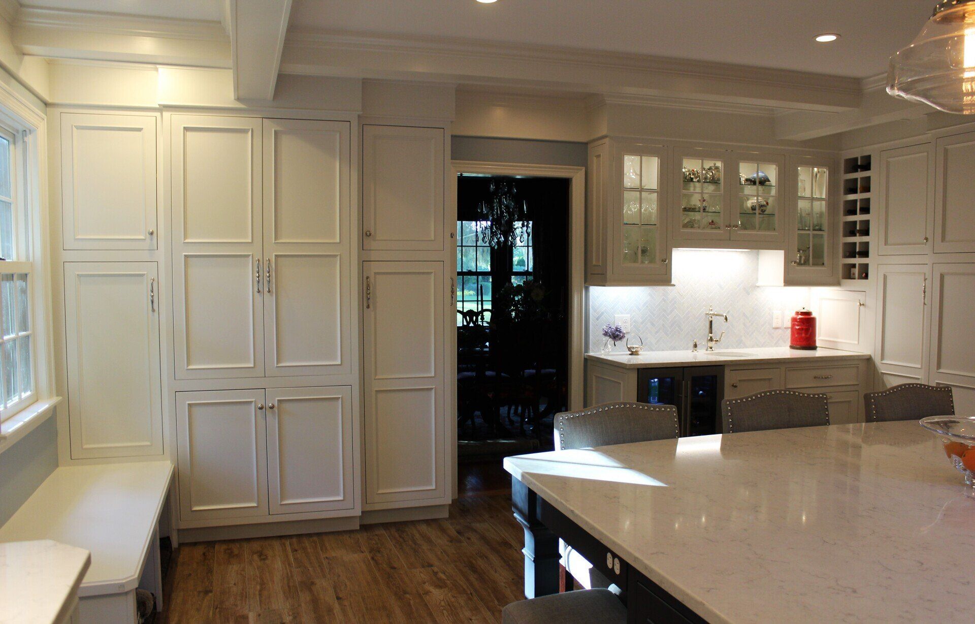 a kitchen with white cabinets and a marble counter top