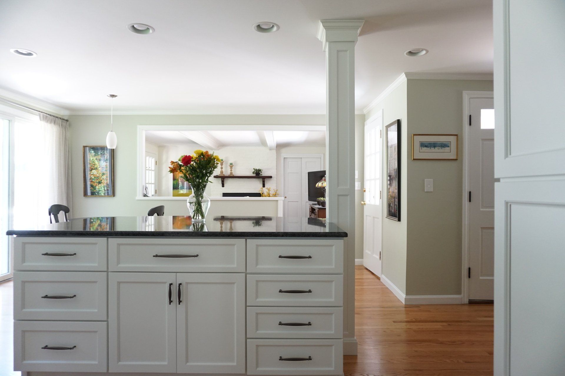 a kitchen with white cabinets and a black counter top