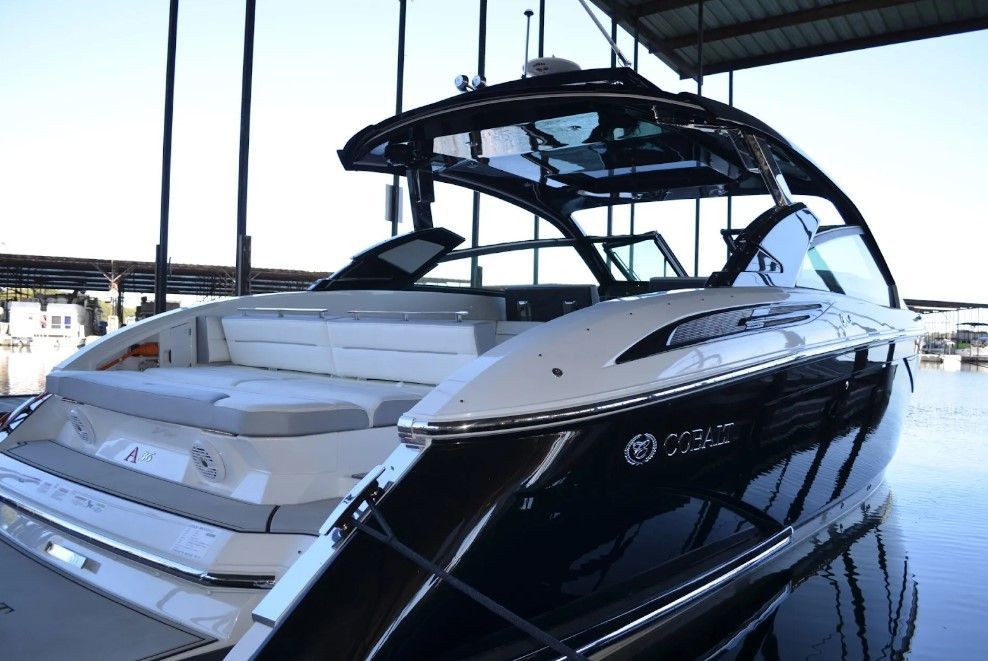 A black and white boat is docked in a marina