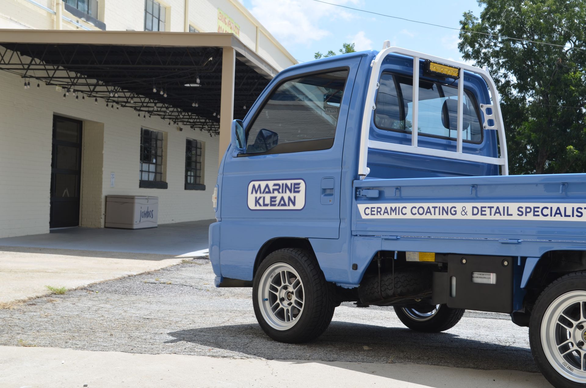 A blue truck that says marine clean is parked in front of a building