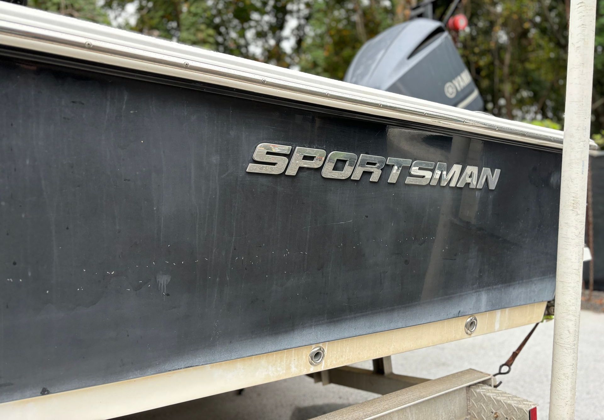 A sportsman boat is parked on the side of the road.