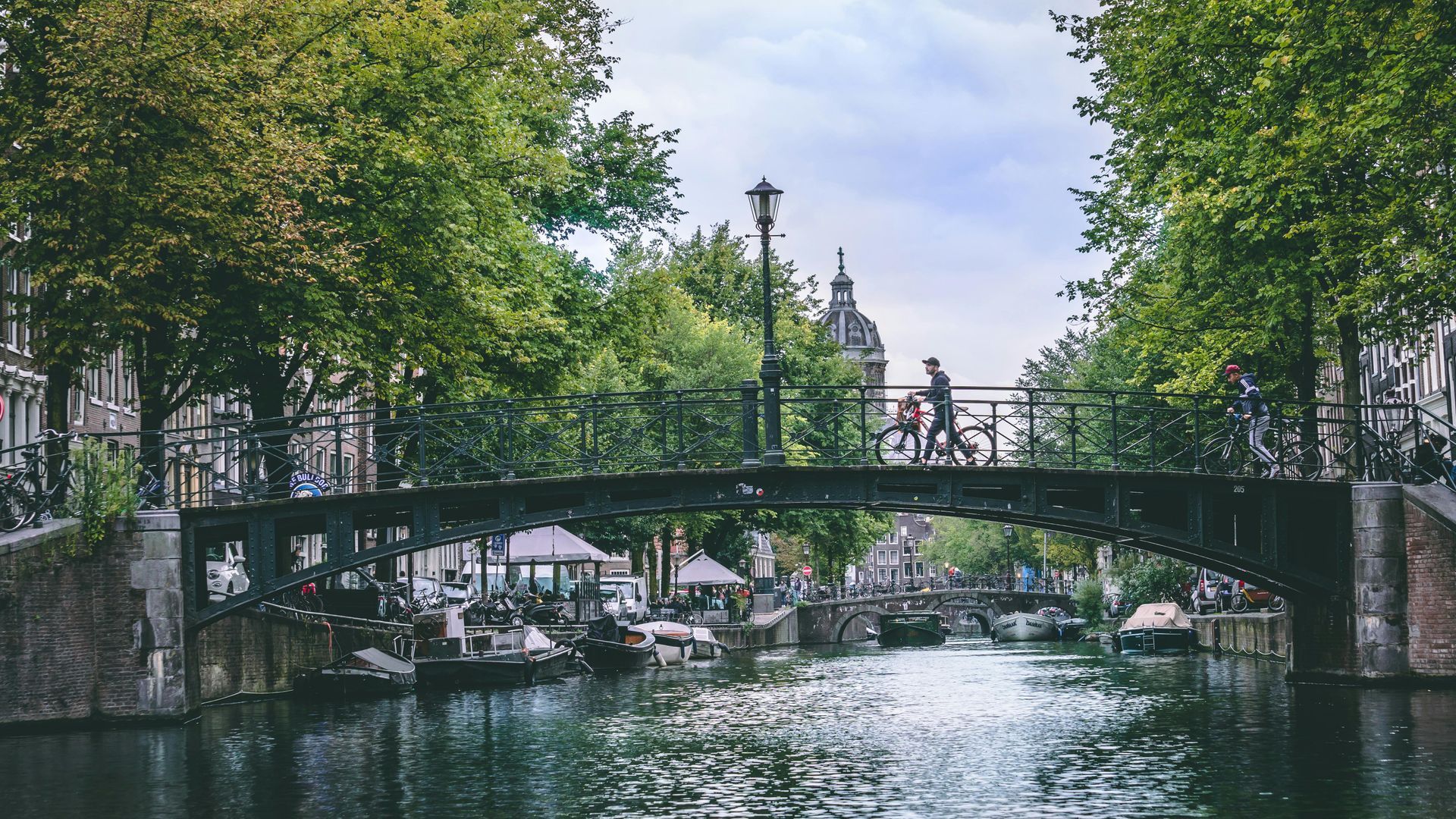 Een rolstoelgebruiker geniet van een toegankelijke rondvaart door de Amsterdamse grachten.