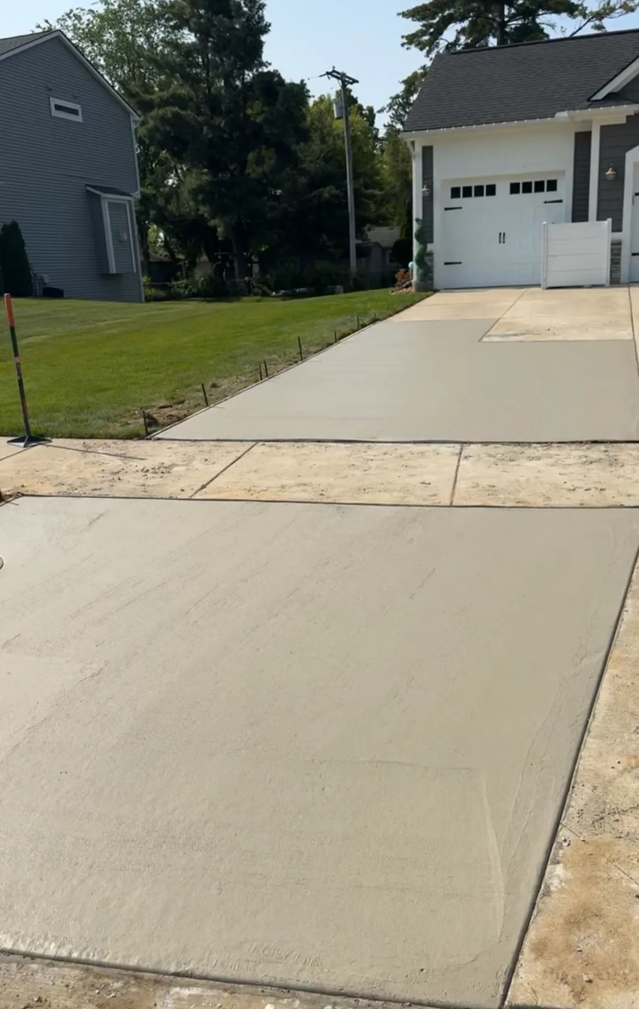 Freshly poured concrete driveway leading to a garage.