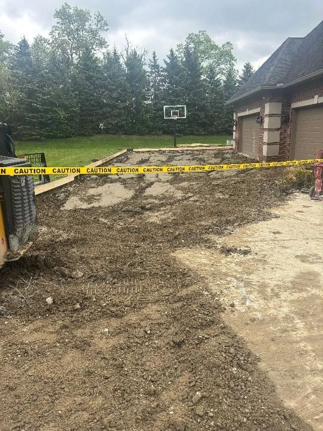 Construction site: Dirt and debris in front of a house. Yellow caution tape surrounds the area.