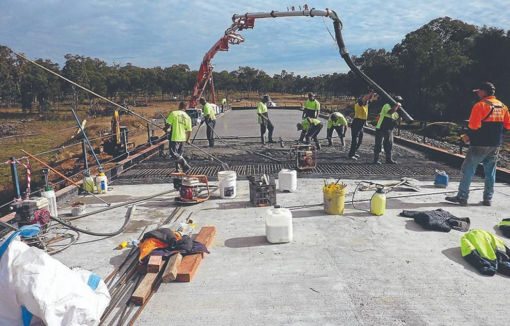 A Group Of Construction Workers Are Working On A Concrete Surface — New England & North West Concrete Pumping In Uralla, NSW