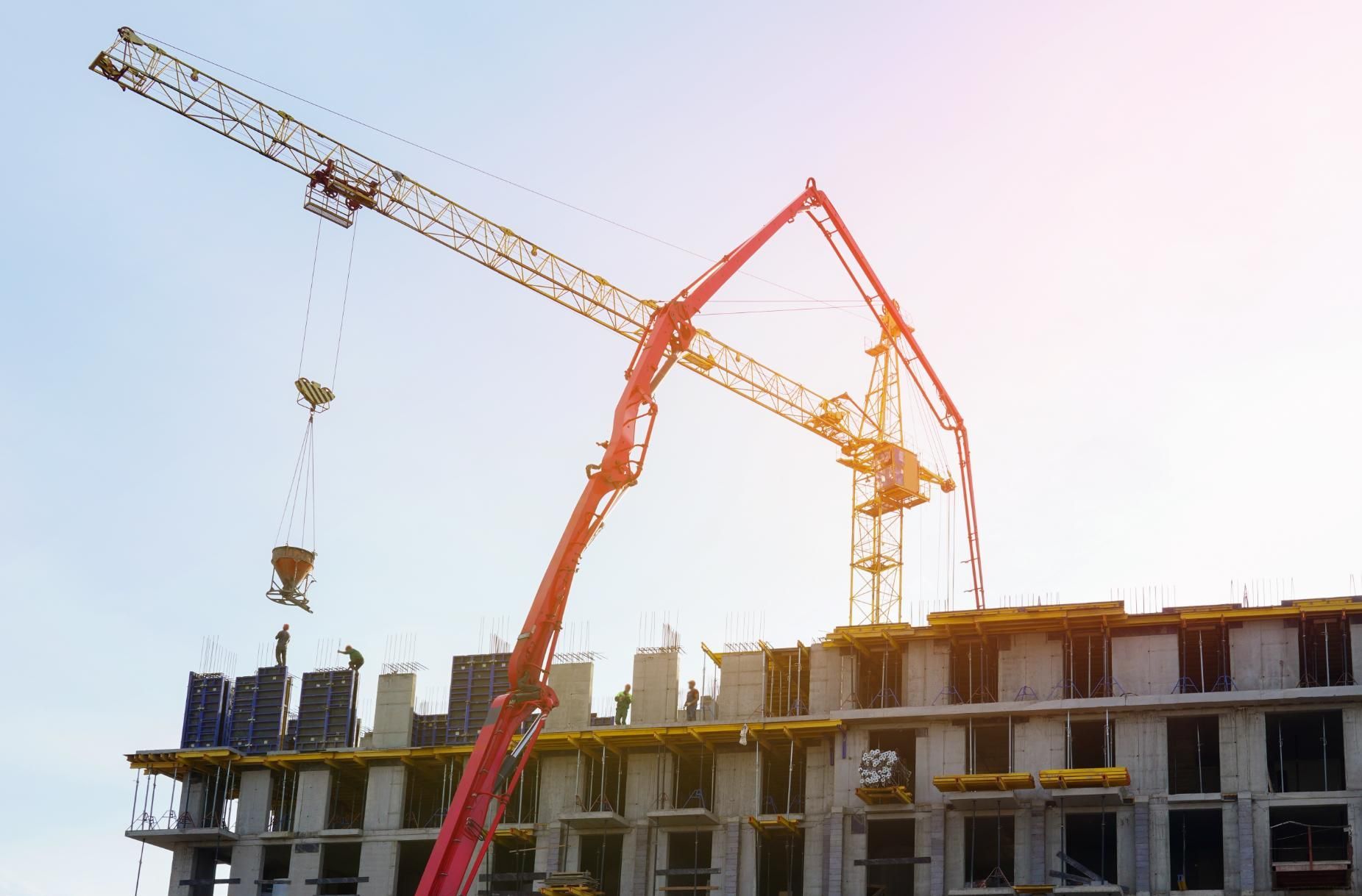 A Large Building Is Being Built With A Crane — New England & North West Concrete Pumping In Uralla, NSW