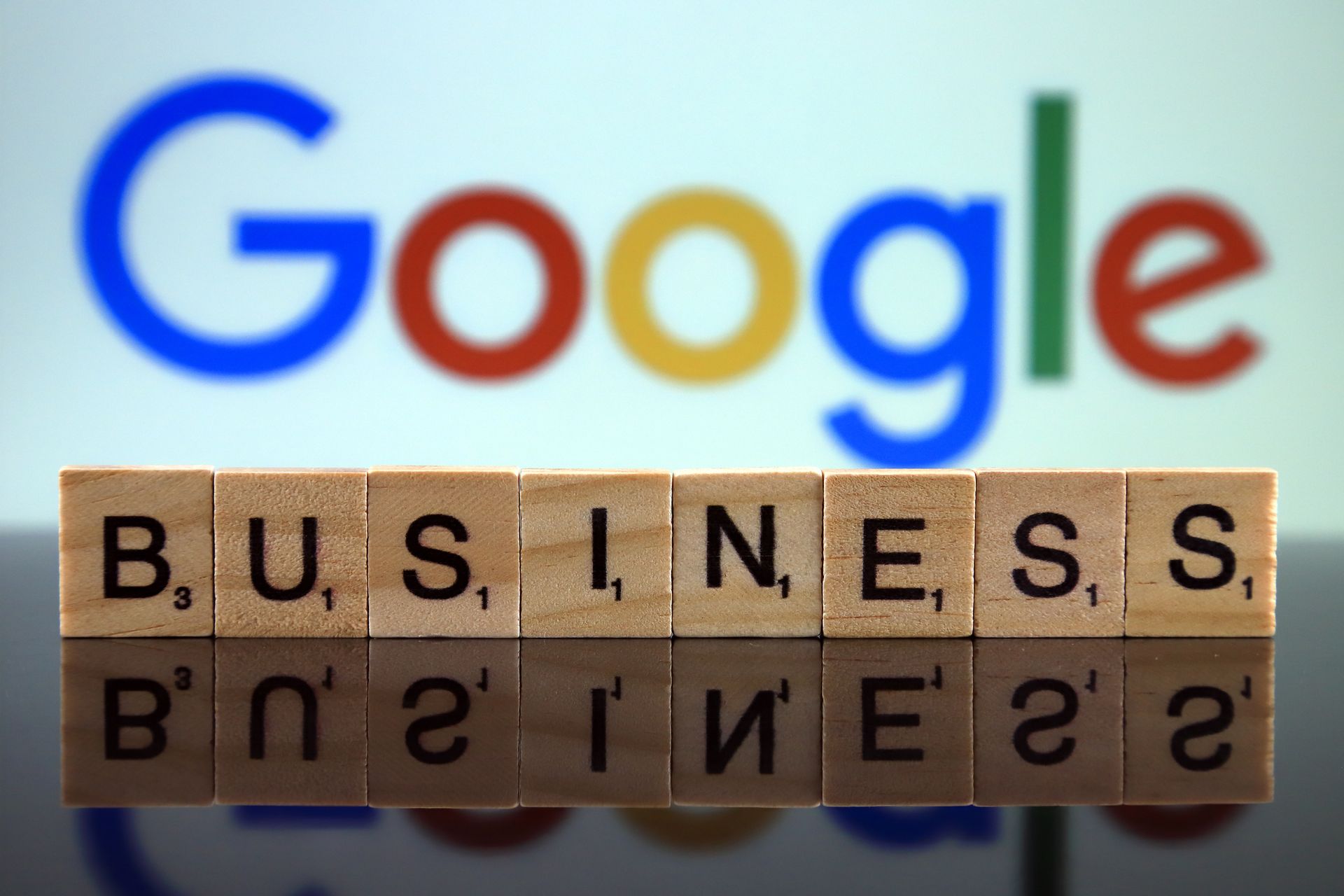 The word business is written on wooden blocks in front of a google logo
