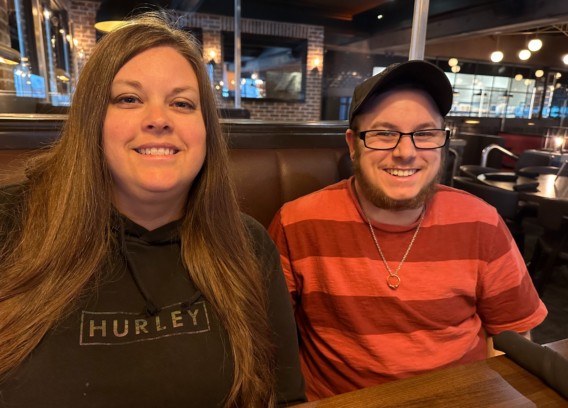 A man and a woman are sitting at a table in a restaurant.