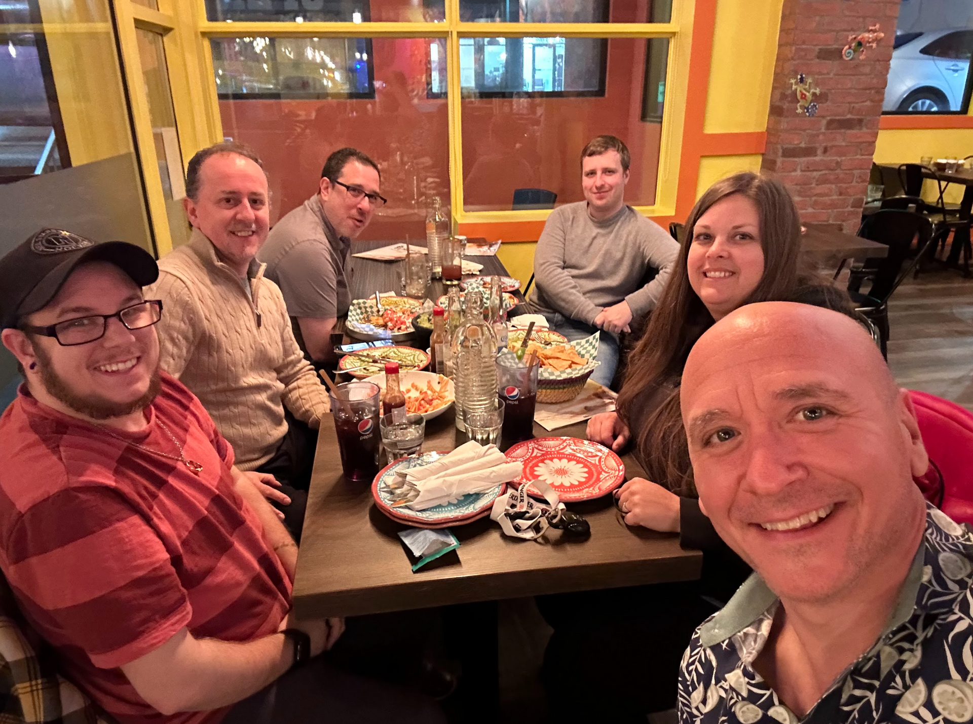 A group of people are sitting at a table in a restaurant eating pizza.