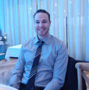 A man in a shirt and tie is smiling for the camera