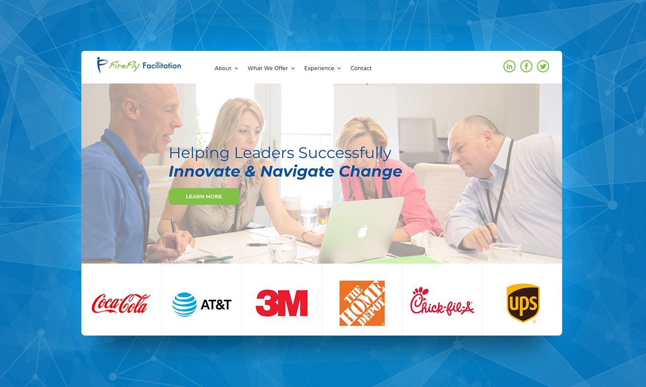 A group of people are sitting around a table with a laptop.