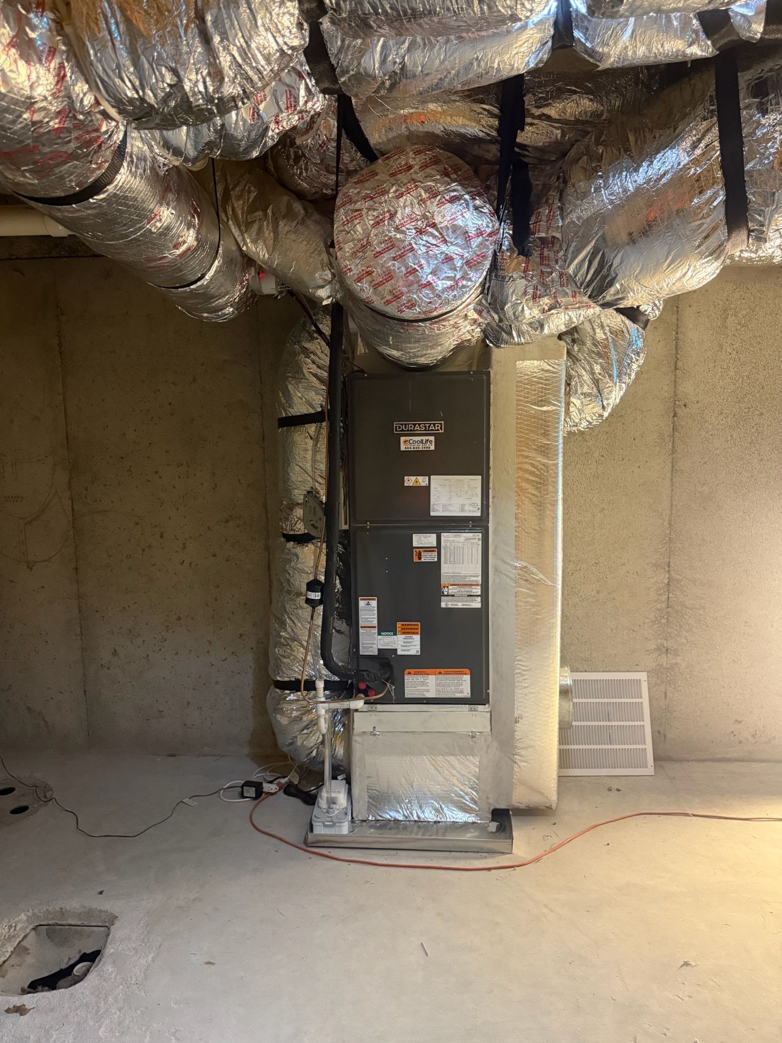Furnace system in a basement with ductwork.