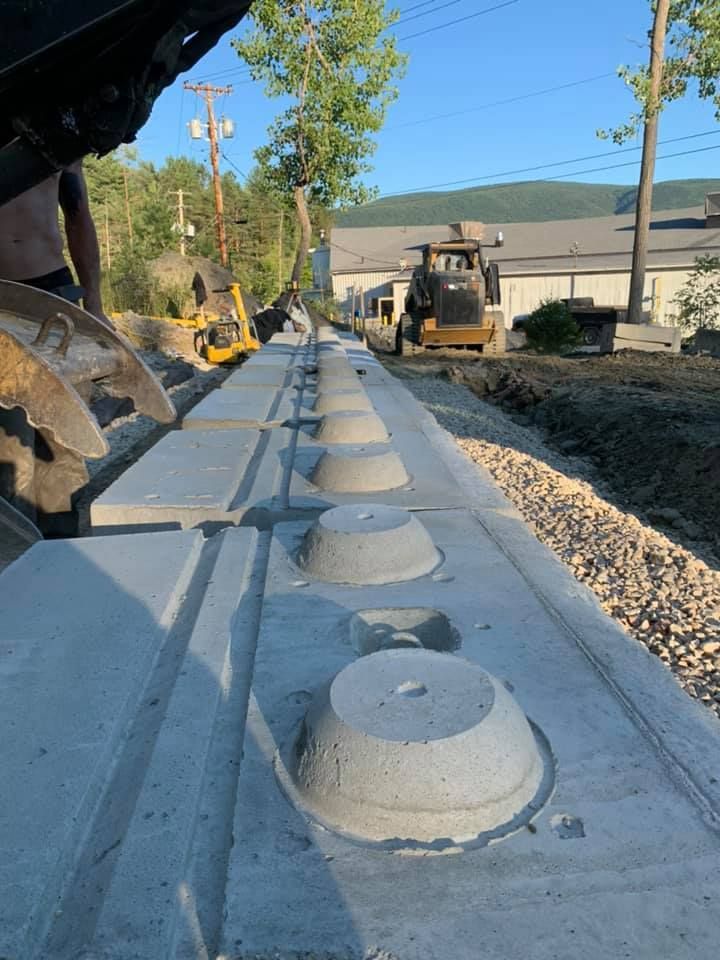 A concrete wall is being built with a bulldozer in the background.