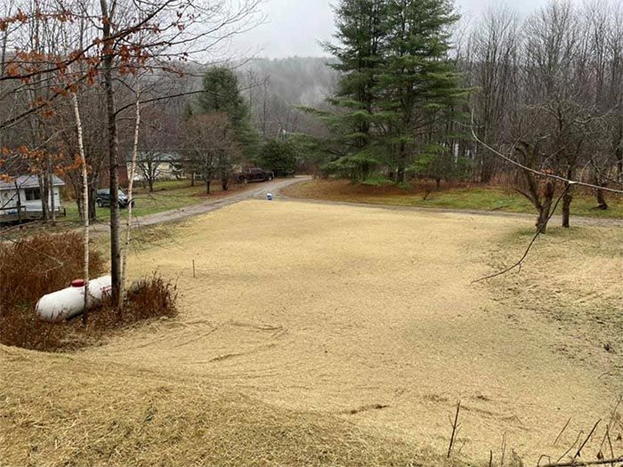 A propane tank is sitting in the middle of a grassy field.