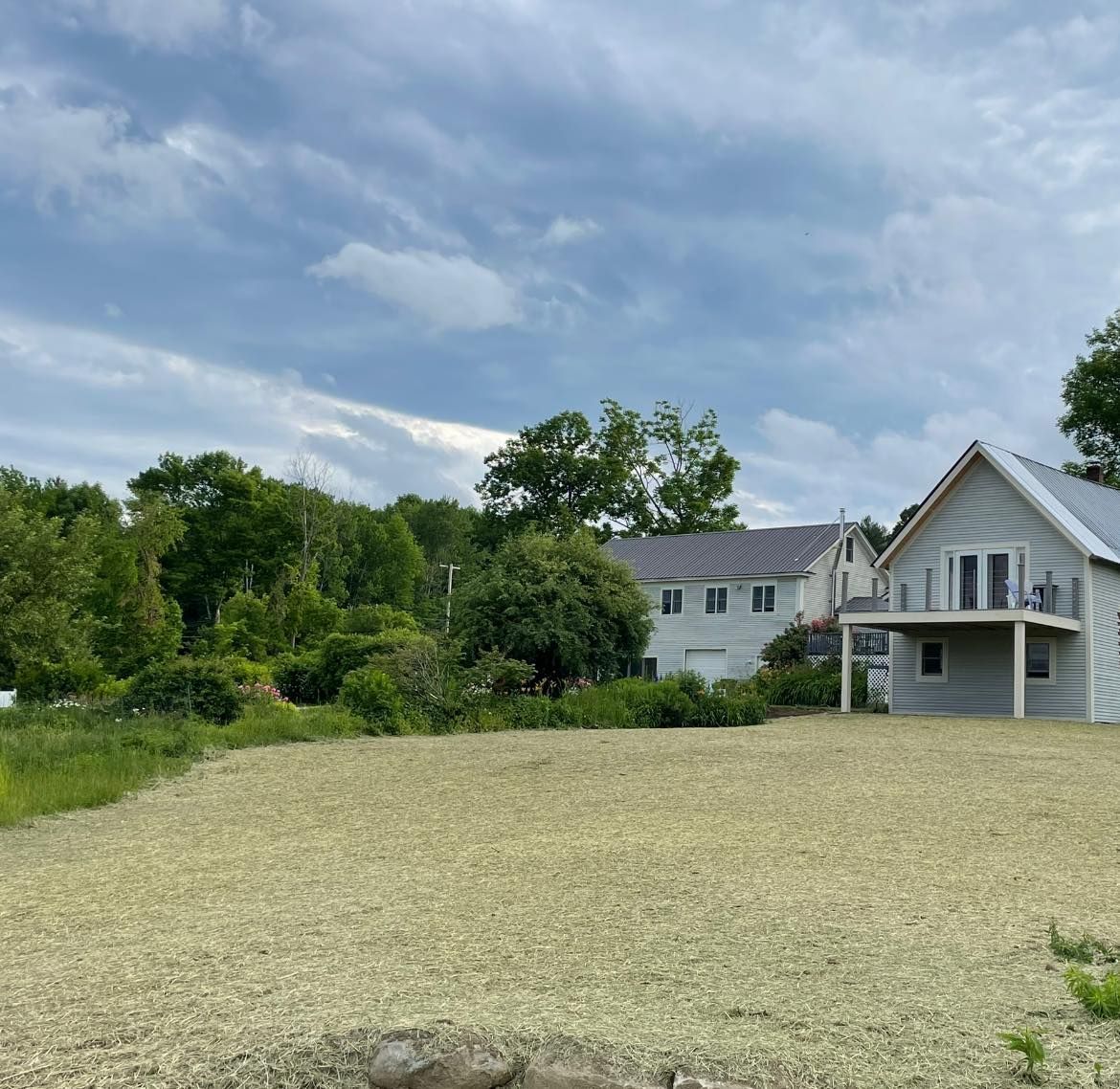 A large white house sits in the middle of a field