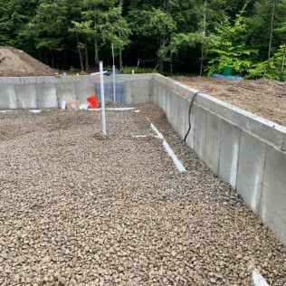 A concrete wall is being built next to a pile of gravel.