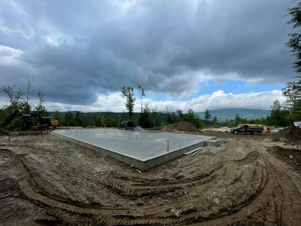A large concrete slab is sitting in the middle of a dirt field.