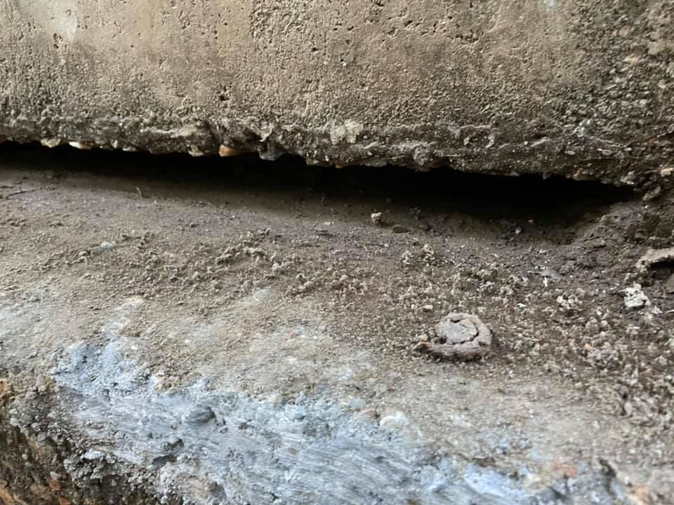 A close up of a concrete wall with a hole in it.
