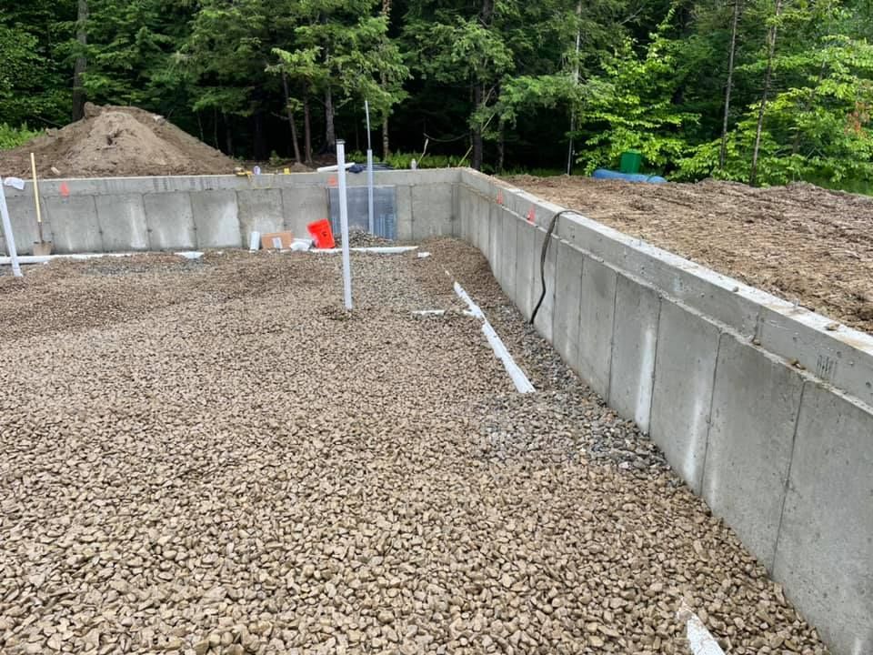 A concrete wall is being built next to a pile of gravel.