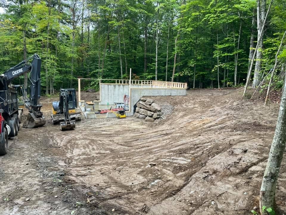 A construction site with a lot of dirt and trees in the background.