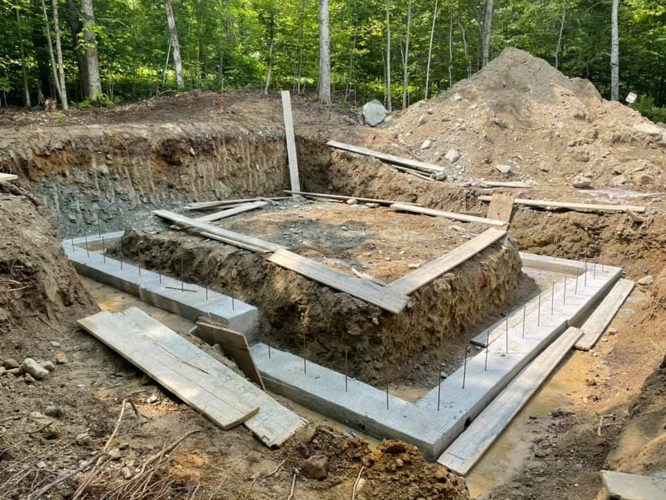 A foundation for a house is being built in the woods.