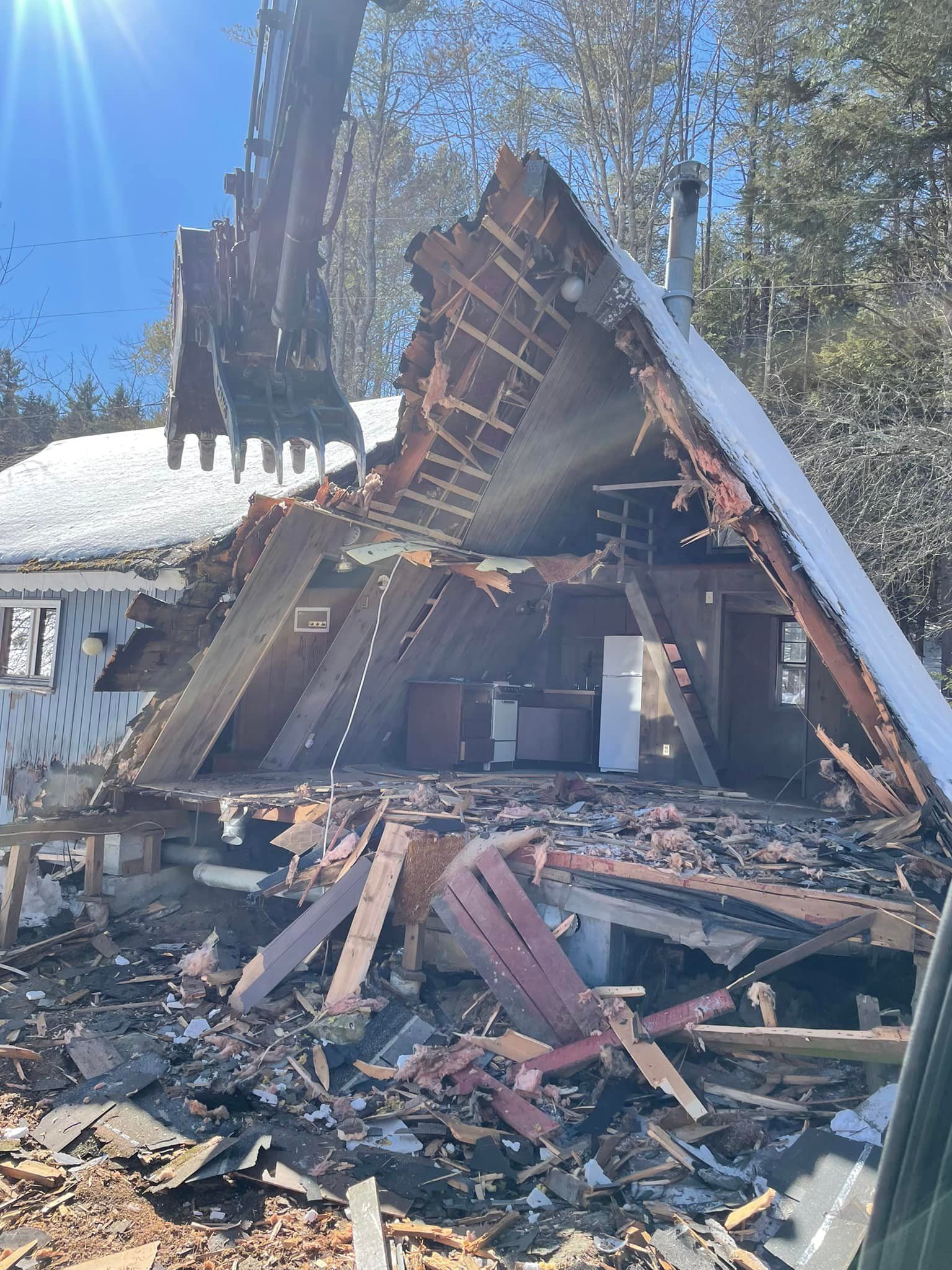A house is being demolished by a crane.