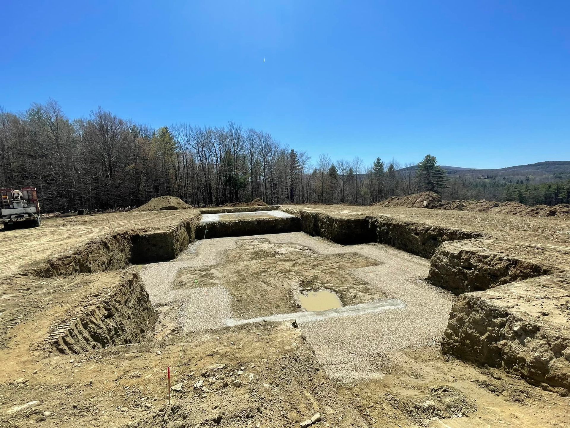 A construction site with a lot of dirt and trees in the background.