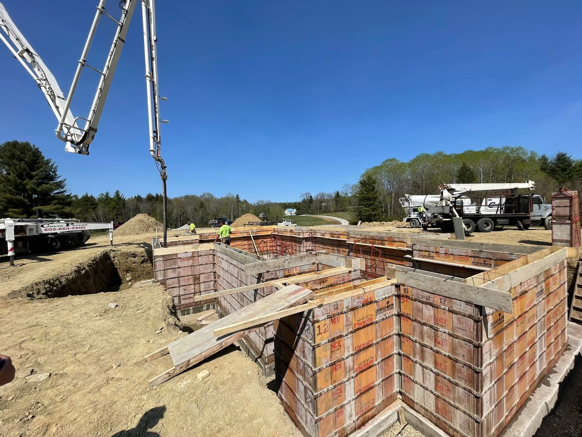A concrete pump is being used to pour concrete into a brick wall.