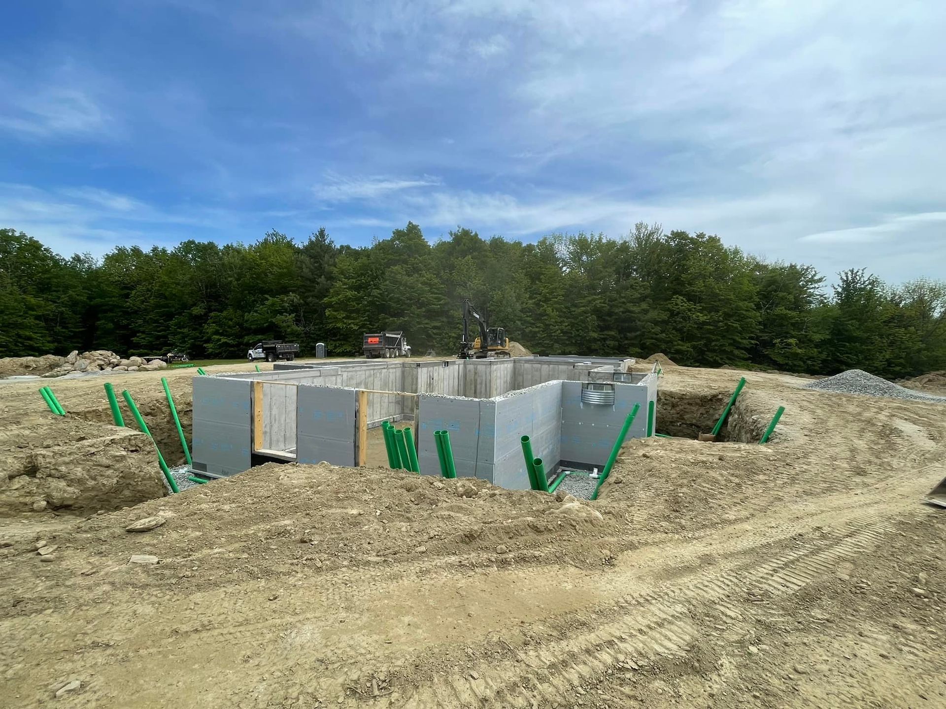 A construction site with a lot of dirt and trees in the background.