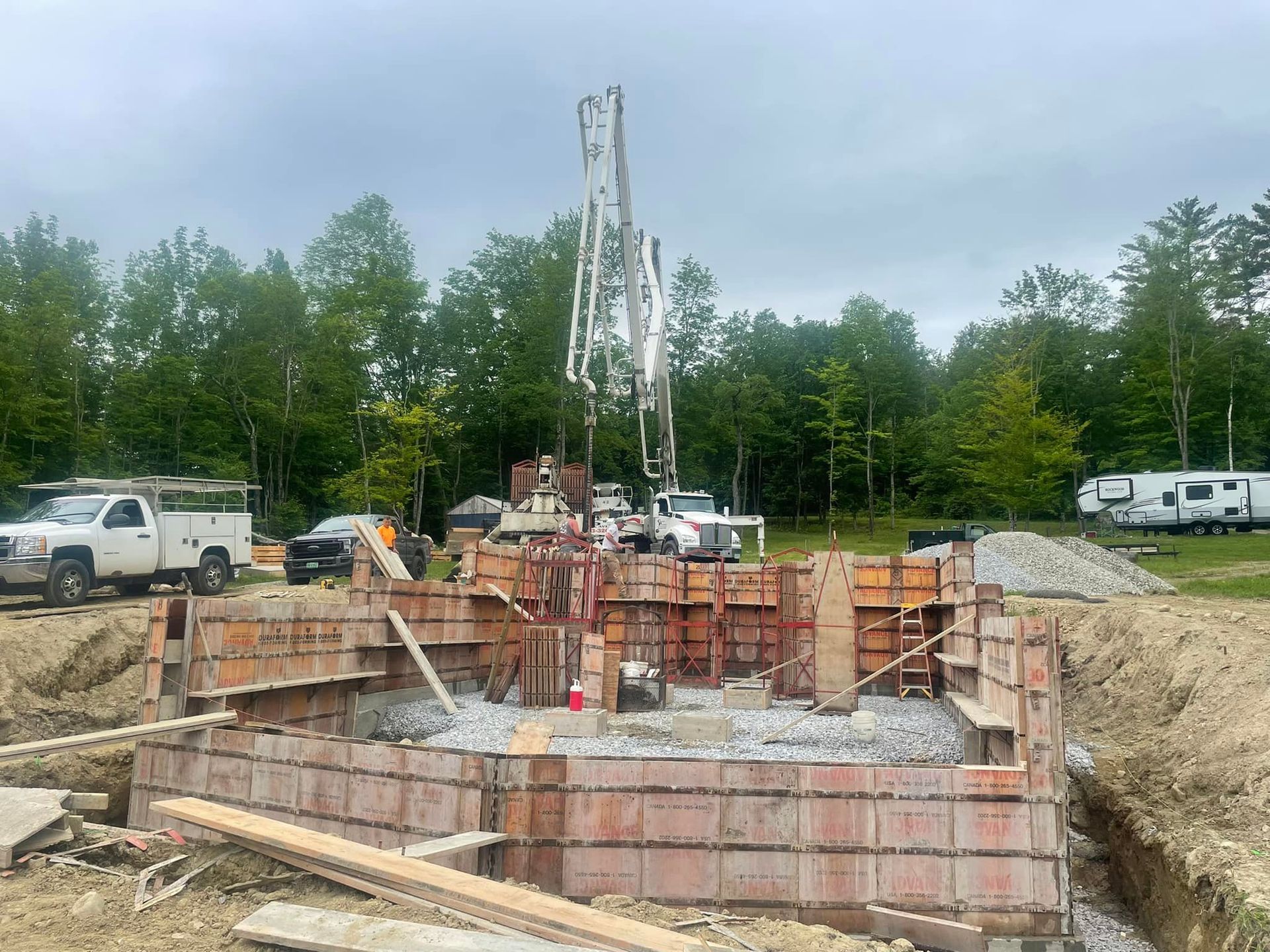 A construction site with a concrete pump in the middle of it.