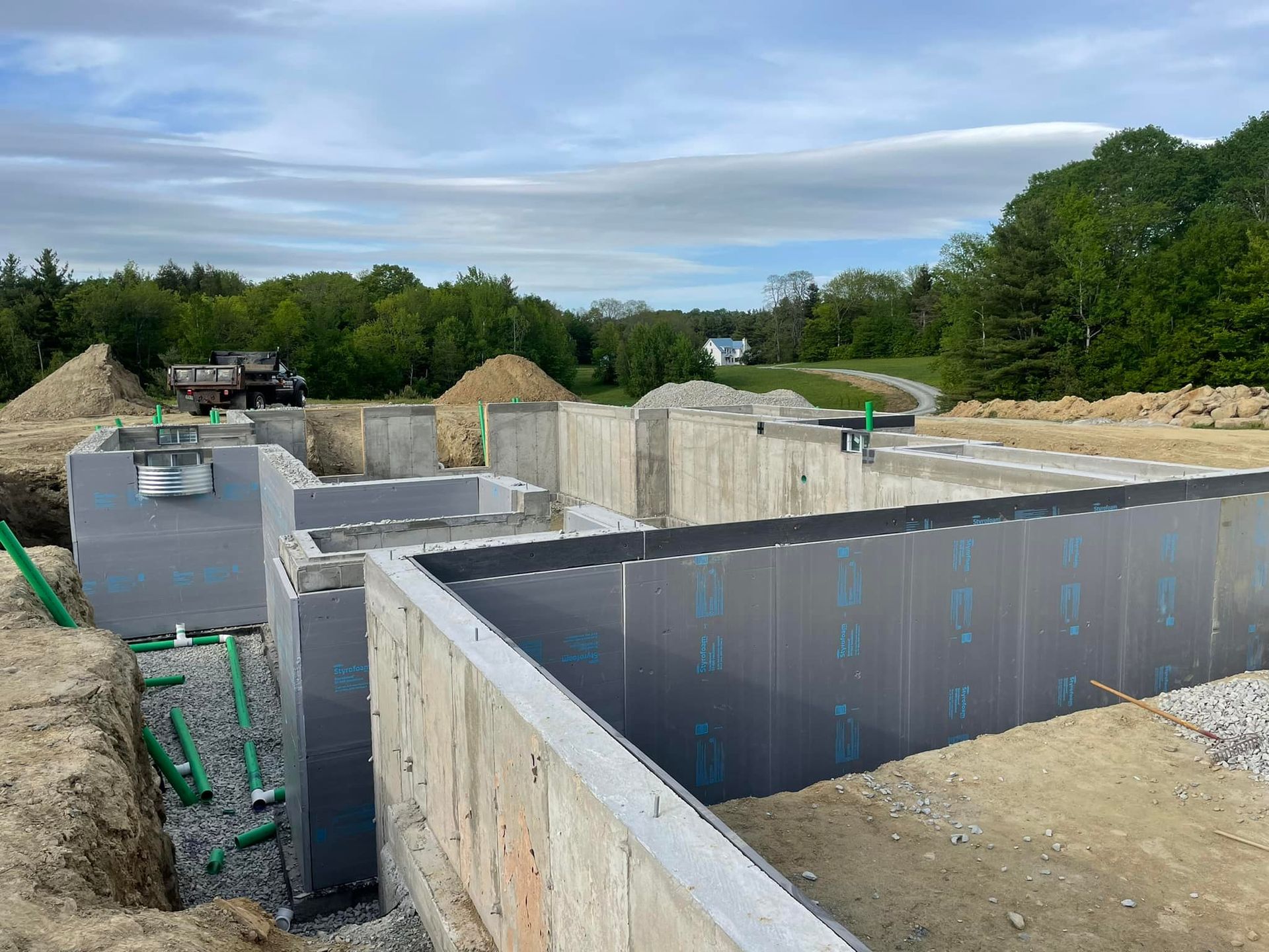 A large concrete wall is being built on a construction site.