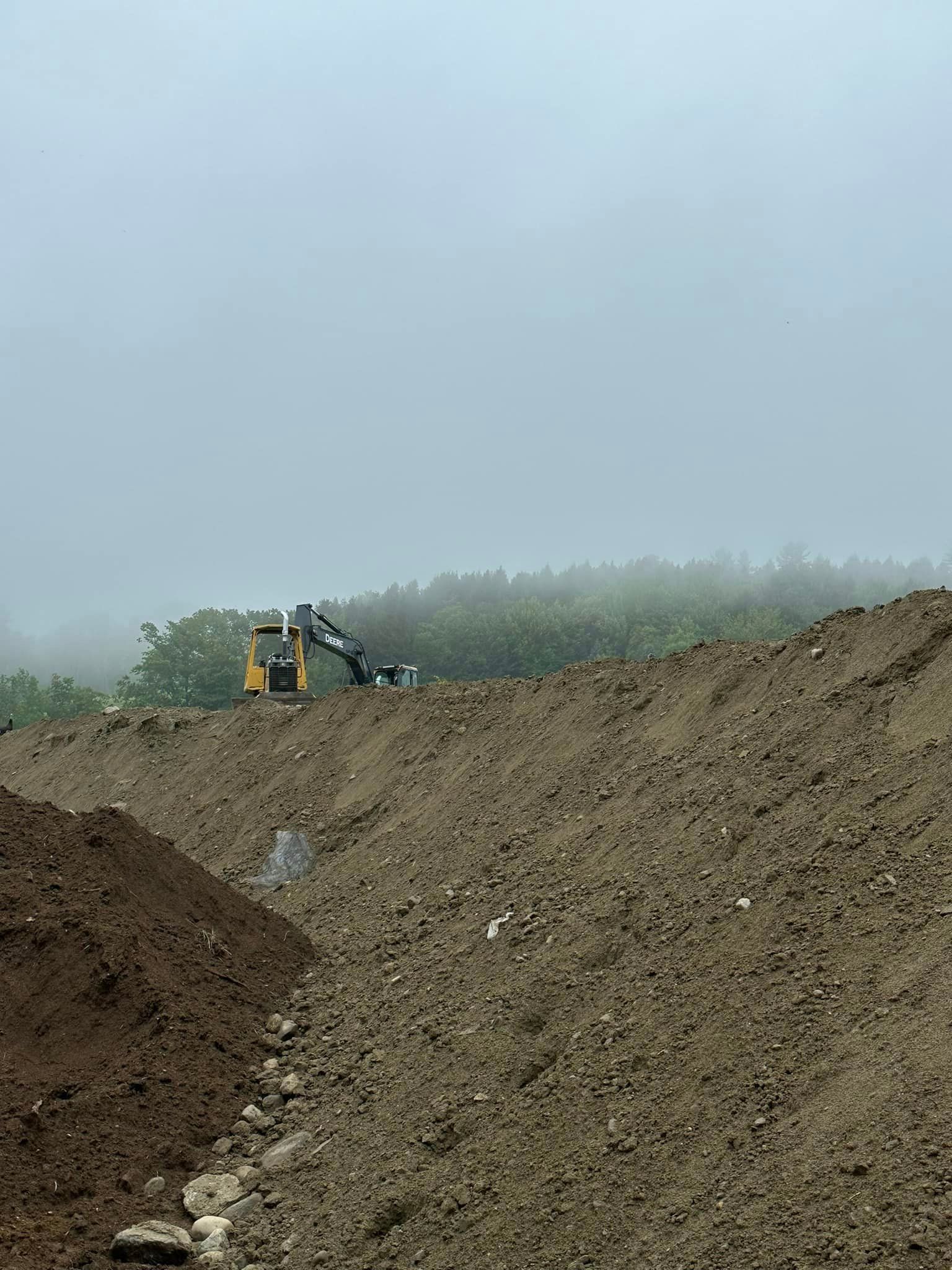 A bulldozer is sitting on top of a pile of dirt.