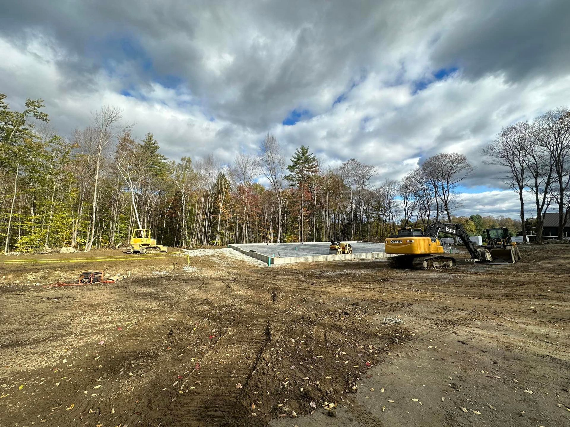 A construction site with a yellow excavator in the middle of it.
