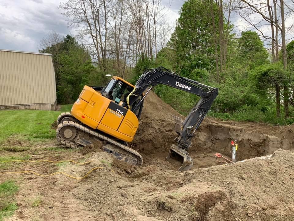 A yellow excavator is digging a hole in the dirt.